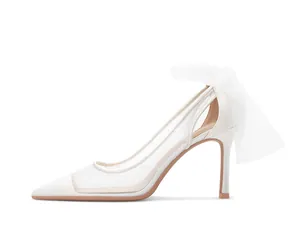 Side view of white pointed toe bridal pumps with polka dot mesh and tulle bow