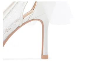Vue détaillée d'un élégant escarpin blanc en dentelle avec un délicat nœud en tulle