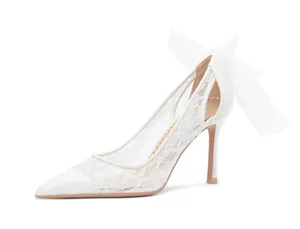 Profil latéral élégant d'un stiletto en dentelle blanche avec nœud en organza.