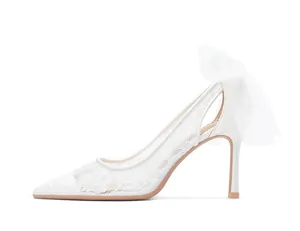 Vue de profil de chaussures de mariée blanches en dentelle avec nœud en tulle élégant