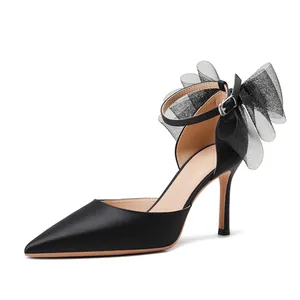 Elegante schwarze spitze High Heels mit einer großen Netzschleife für Hochzeiten.