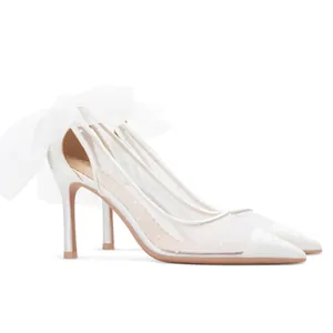 Elegant white pointed toe stiletto pumps with polka dot mesh and large tulle bow