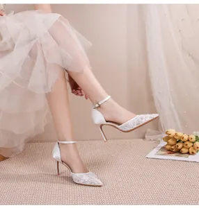 Escarpins de mariage élégants en dentelle blanche avec bride à la cheville en studio