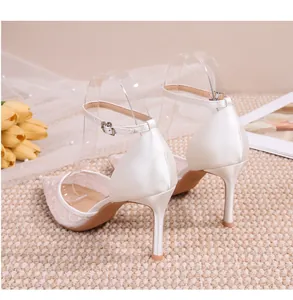 Vue détaillée d'élégants talons de mariée en dentelle blanche avec bride cheville.