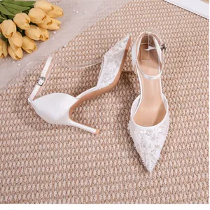 Vue détaillée de chaussures de mariée élégantes en dentelle blanche avec bride