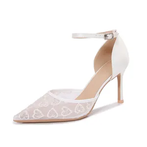 Vue détaillée des chaussures de mariage en dentelle blanche avec jolis motifs de cœur