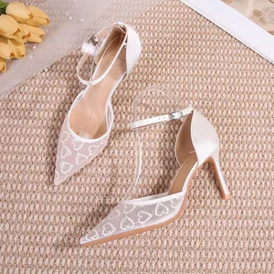 Chaussures de mariée élégantes en dentelle blanche avec motifs de cœurs et bride