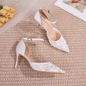 Gros plan sur les élégantes chaussures de mariée en dentelle blanche avec bride cheville.