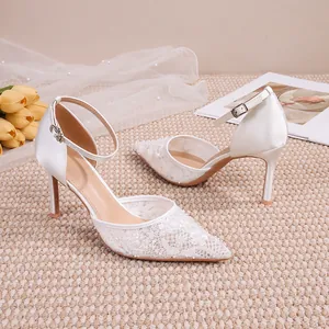 Détail de chaussures de mariage en dentelle blanche avec paillettes et bride à la cheville