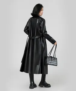 Vue arrière d'un long trench-coat élégant en cuir noir pour femme avec une ceinture.