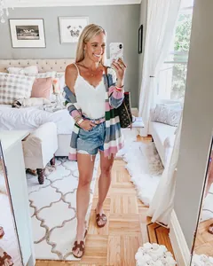 Mujer con un cárdigan de punto a rayas multicolores en una habitación muy acogedora
