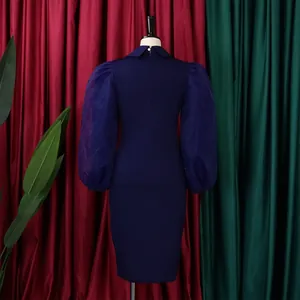 Back view of elegant navy blue pencil dress featuring sheer mesh puff sleeves on mannequin.