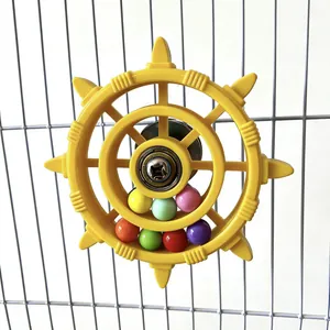 Close-up of a yellow rotating ship wheel toy with colorful beads for bird cages