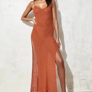 Close-up of orange knitted see-through maxi dress with high side slit for resort wear.