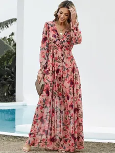 Elegant long-sleeved maxi dress with pink floral print and ruffled v-neckline.