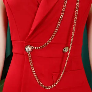 Close-up of red fashion jumpsuit with gold chain and button details on the waist