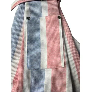 Close-up of the durable front pocket with metal snap buttons on the striped pet sling carrier