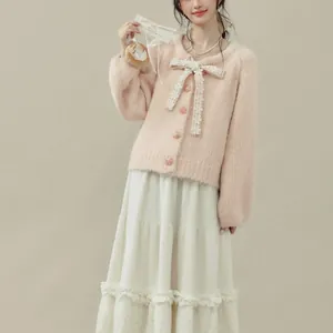 Vista dettagliata del cardigan in maglia rosa con fiocco in pizzo e bottoni floreali