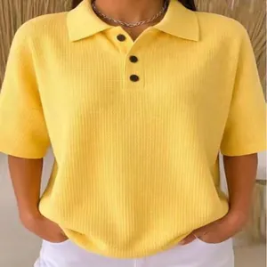 Detailed view of yellow waffle knit fabric texture on women's short sleeve polo shirt