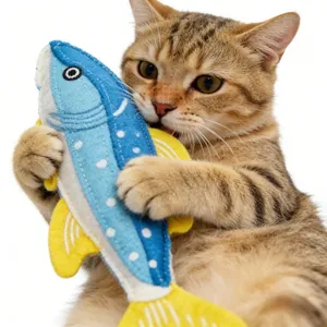 Nahaufnahme einer Katze, die mit einem realistischen Plüschfisch-Spielzeug spielt