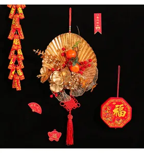 Chinese New Year wall decoration featuring a golden fan with red berries and tassel
