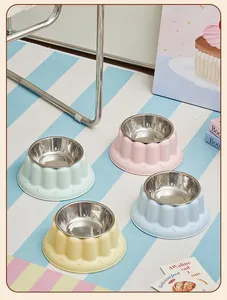 Four colorful anti-tip pet bowls with stainless steel inserts on a blue striped rug.