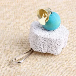 Vue détaillée de la pierre à broyer pour perroquets avec perle en bois et cloche