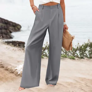 Vista completa di pantaloni grigi a vita alta a gamba larga da donna su uno sfondo di spiaggia