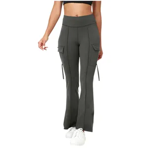 Detail of high-waisted flare yoga pants with cargo pockets in dark grey color