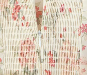 Close-up of floral print dress showing smocked bodice texture and invisible zipper detail.