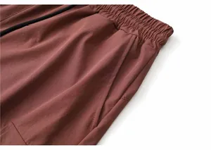Close-up detail of brick red quick-dry cargo shorts showing waistband and pocket texture
