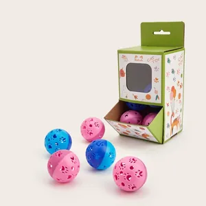 Dettaglio di palline cave per gatti con impronte di zampe e confezione regalo verde