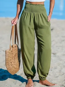 Detailed view of olive green loose beach joggers featuring smocked high waist and elastic cuffs