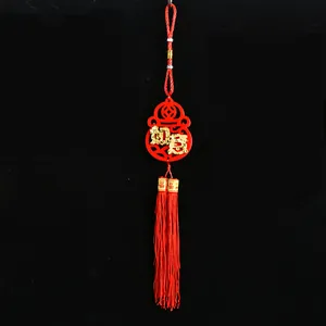 Close-up of red felt Chinese New Year ornament with gold Ruyi character and long tassels