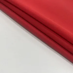 Detailed macro view of vibrant red woven fabric texture for a women's summer dress