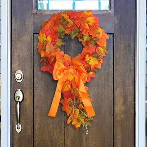 Handmade autumn harvest maple leaf wreath featuring a large orange bow for home door decoration.
