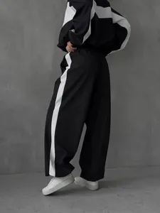 Detailed side view of women's black and white color-blocked baggy leisure tracksuit set