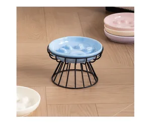 Close-up detail of a ceramic cat paw slow feeder bowl with an elevated black iron stand