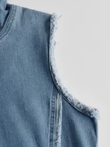 Primer plano de los bordes deshilachados en un vestido vaquero azul de estilo retro.
