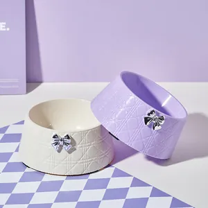 Gamelles antidérapantes stylées avec motif losanges surpiqués et décoration nœud papillon argent.