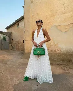 Vue détaillée de la robe longue dos nu blanche avec des textures florales 3D pour l'été.