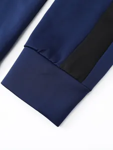 Detail of navy blue sports suit cuff with black side stripe contrast stitching