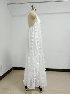 Detailed side view of white halter maxi dress with 3D floral appliqués on a mannequin