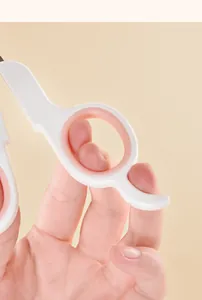 Detailed macro view of ergonomic pink and white handle on pet nail clippers for cats