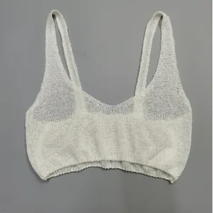 Close-up of white knitted fabric texture on a minimalist bralette style crop top.