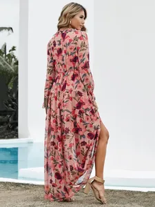 Back view of a pink floral long sleeve maxi dress with a tiered skirt and high slit