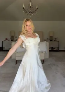Detailweergave van de kantafwerking en satijnen stof van deze romantische off-shoulder jurk