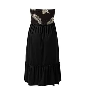 Back view of a black strapless tube dress featuring smocked bodice and tropical leaf print