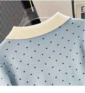 Close-up of light blue knitted cardigan with polka dots and white lapel collar