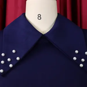 Close-up of elegant pearl bead embellishment on navy blue dress lapel collar detail